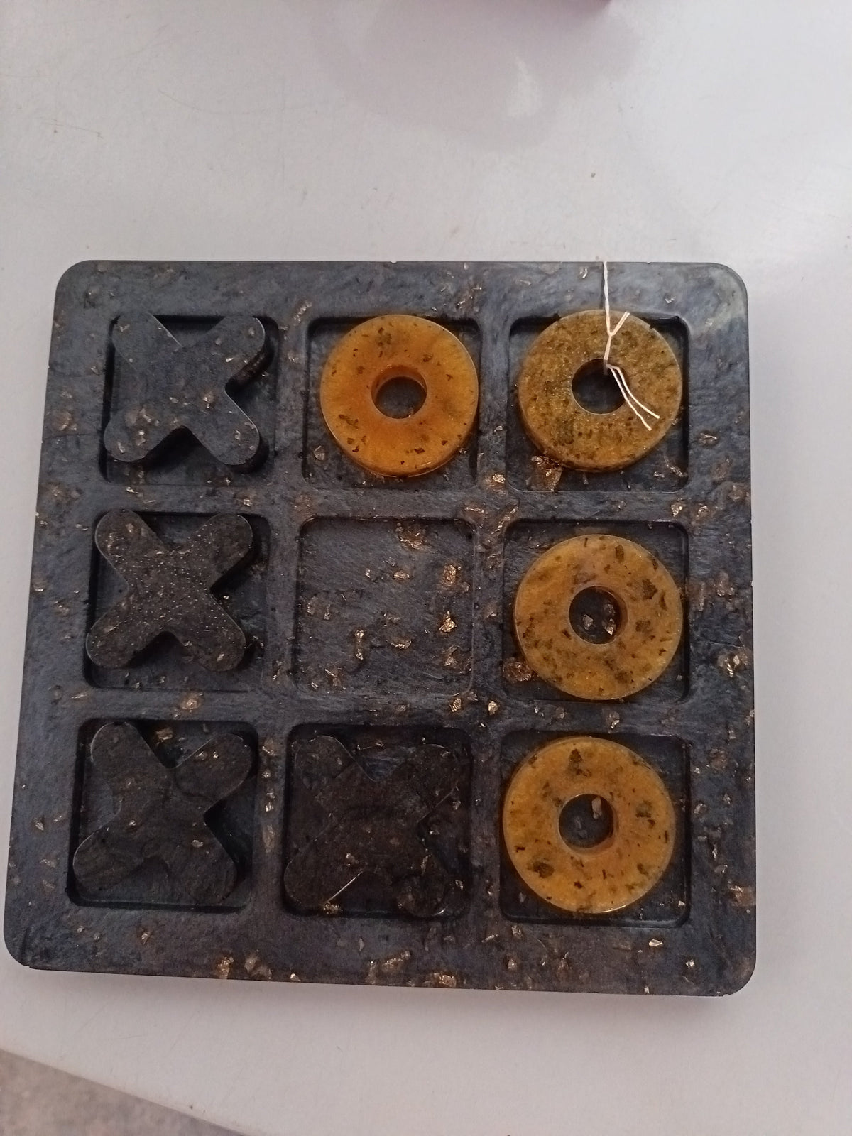Jeu de morpion en résine époxy noir marbré avec pions dorés et noirs