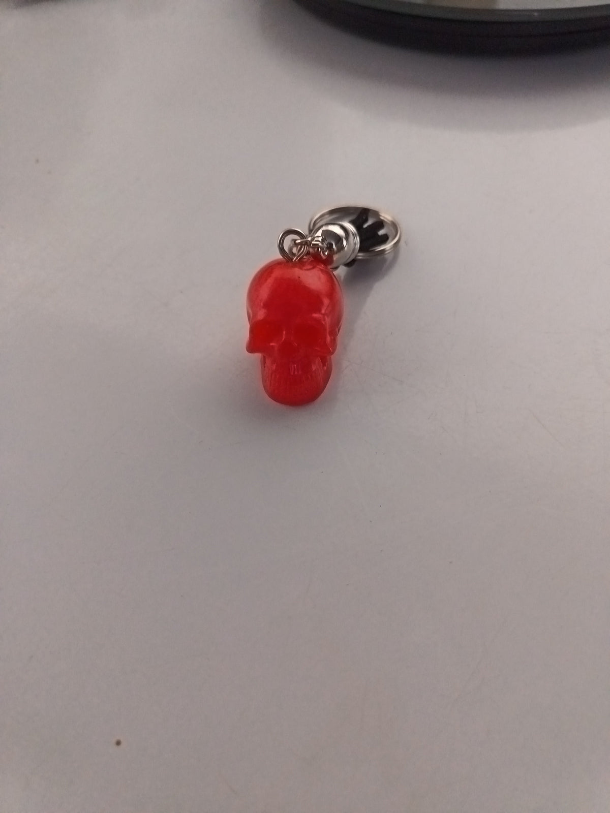 Porte-clé tête de mort sculptée en résine rouge vif avec anneau métallique argenté