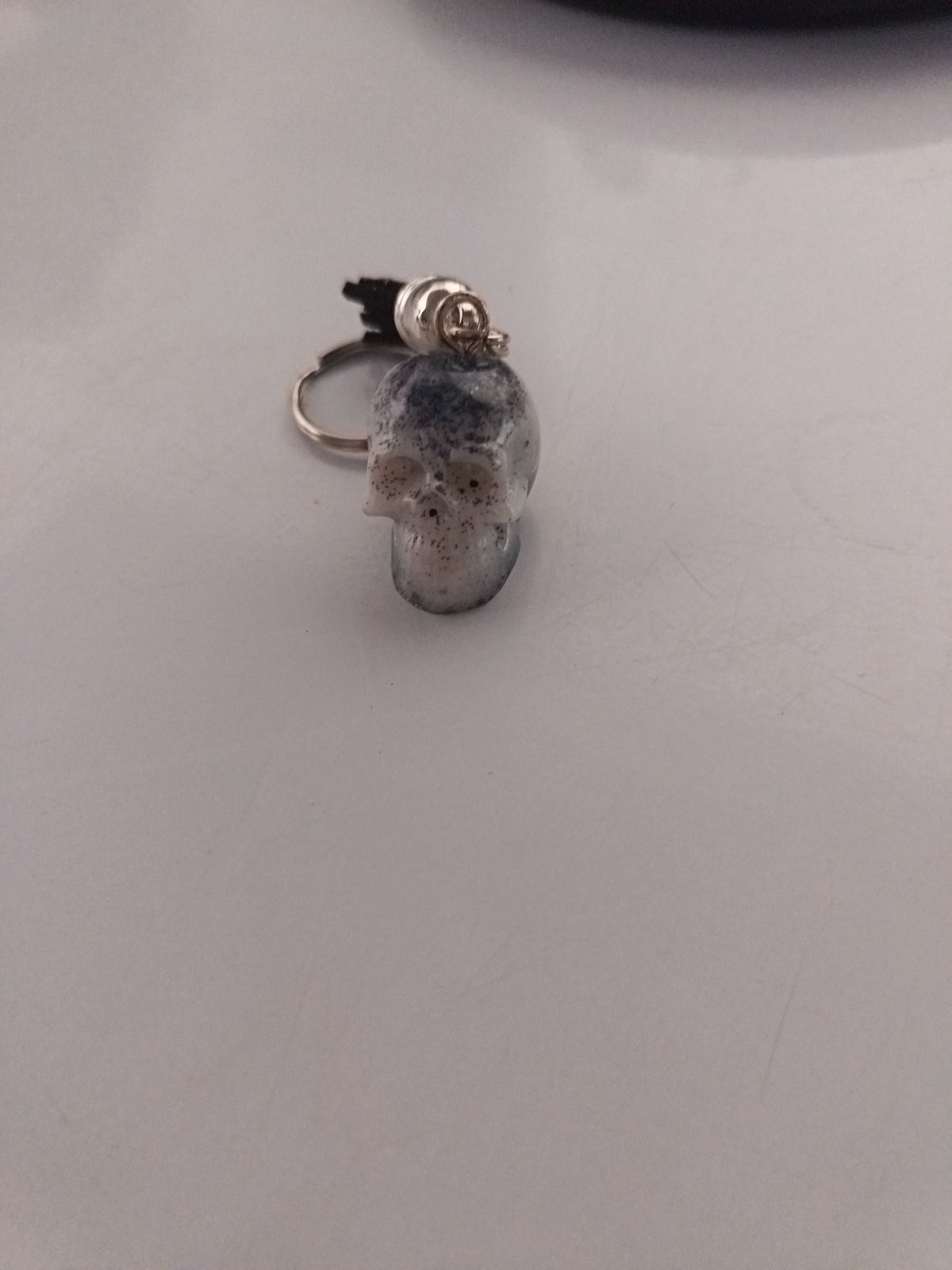 Porte-clé tête de mort sculptée en résine translucide avec inclusions galaxy bleu-gris