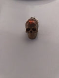 Porte-clé tête de mort sculptée en résine beige-taupe avec paillettes oranges-cuivrées
