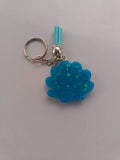 Porte-clé coquillage en résine bleu turquoise pailleté avec pompon suédine bleu ciel