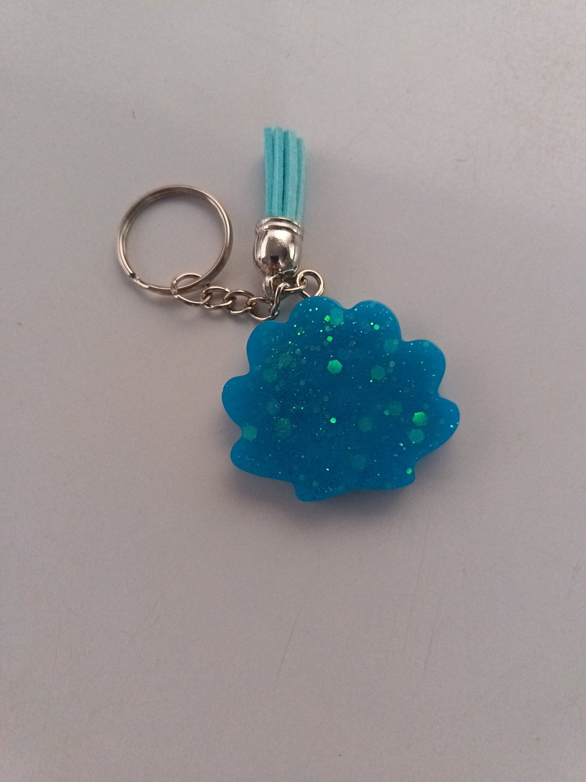 Porte-clé coquillage en résine bleu turquoise pailleté avec pompon suédine bleu ciel