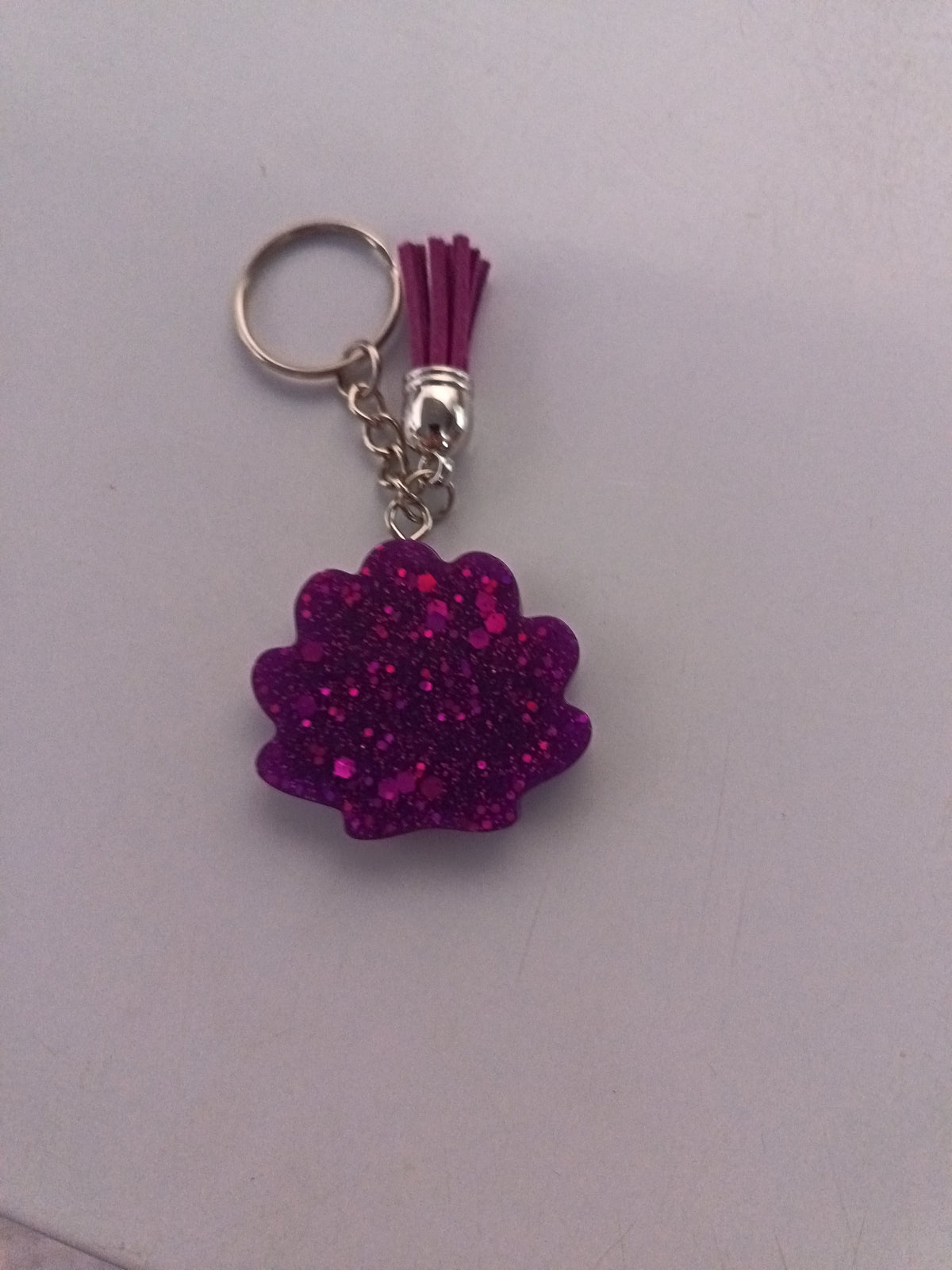 Porte-clé coquillage en résine violet-fuchsia ultra-pailleté avec pompon suédine violet