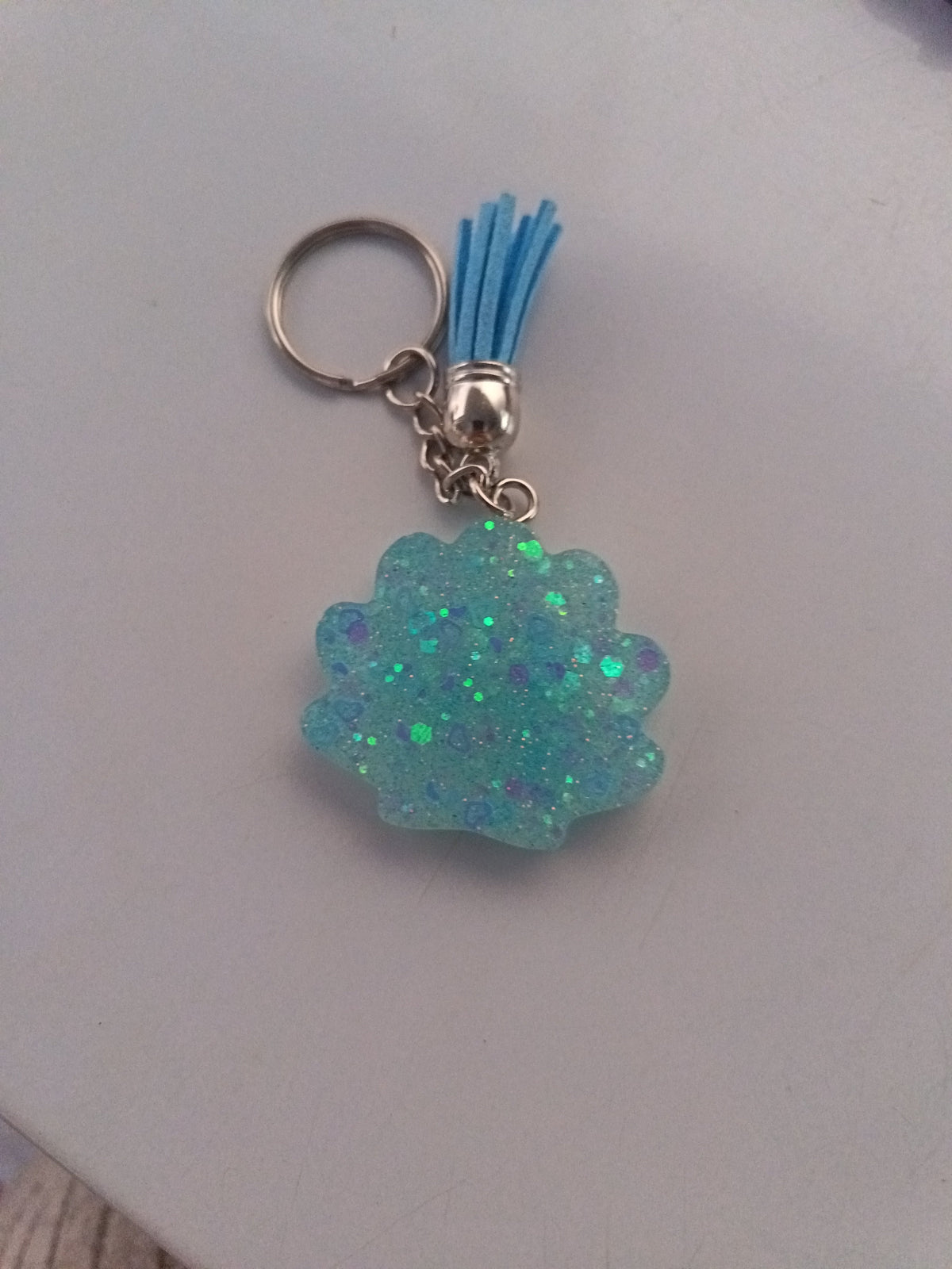 Porte-clé coquillage en résine vert menthe irisé avec paillettes et pompon suédine bleu ciel