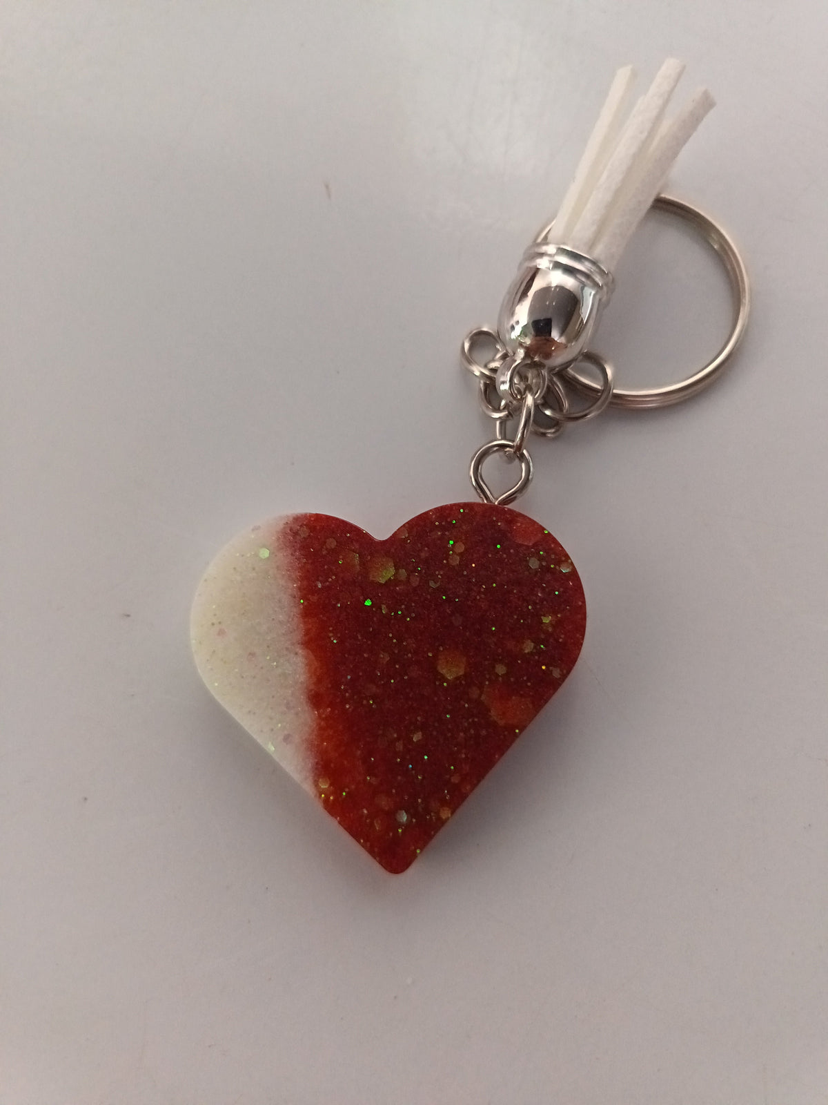 Porte-clé cœur en résine bicolore rouge pailleté et blanc nacré avec pompon suédine blanc