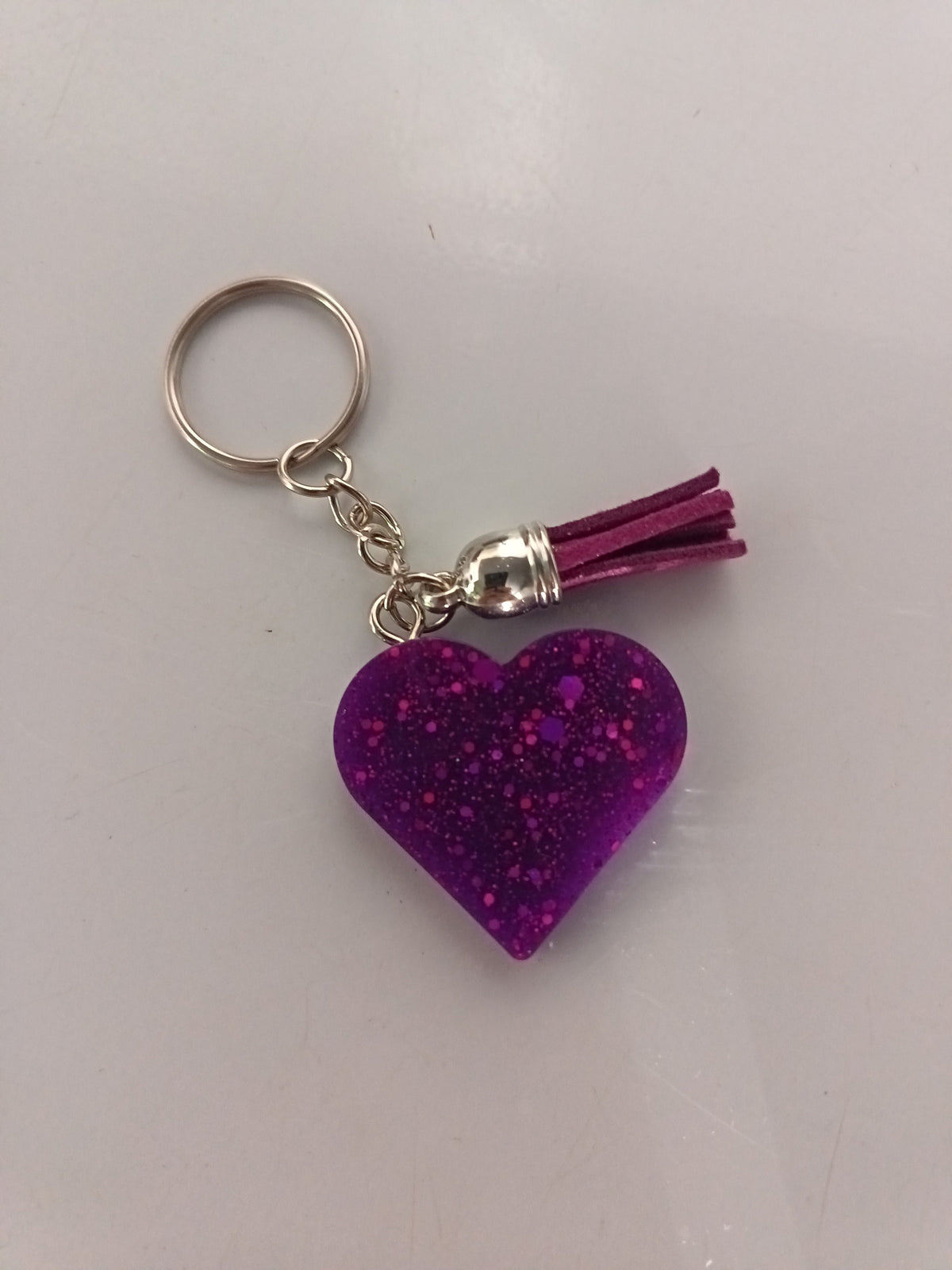 Porte-clé cœur en résine violet-mauve pailleté avec pompon suédine violet