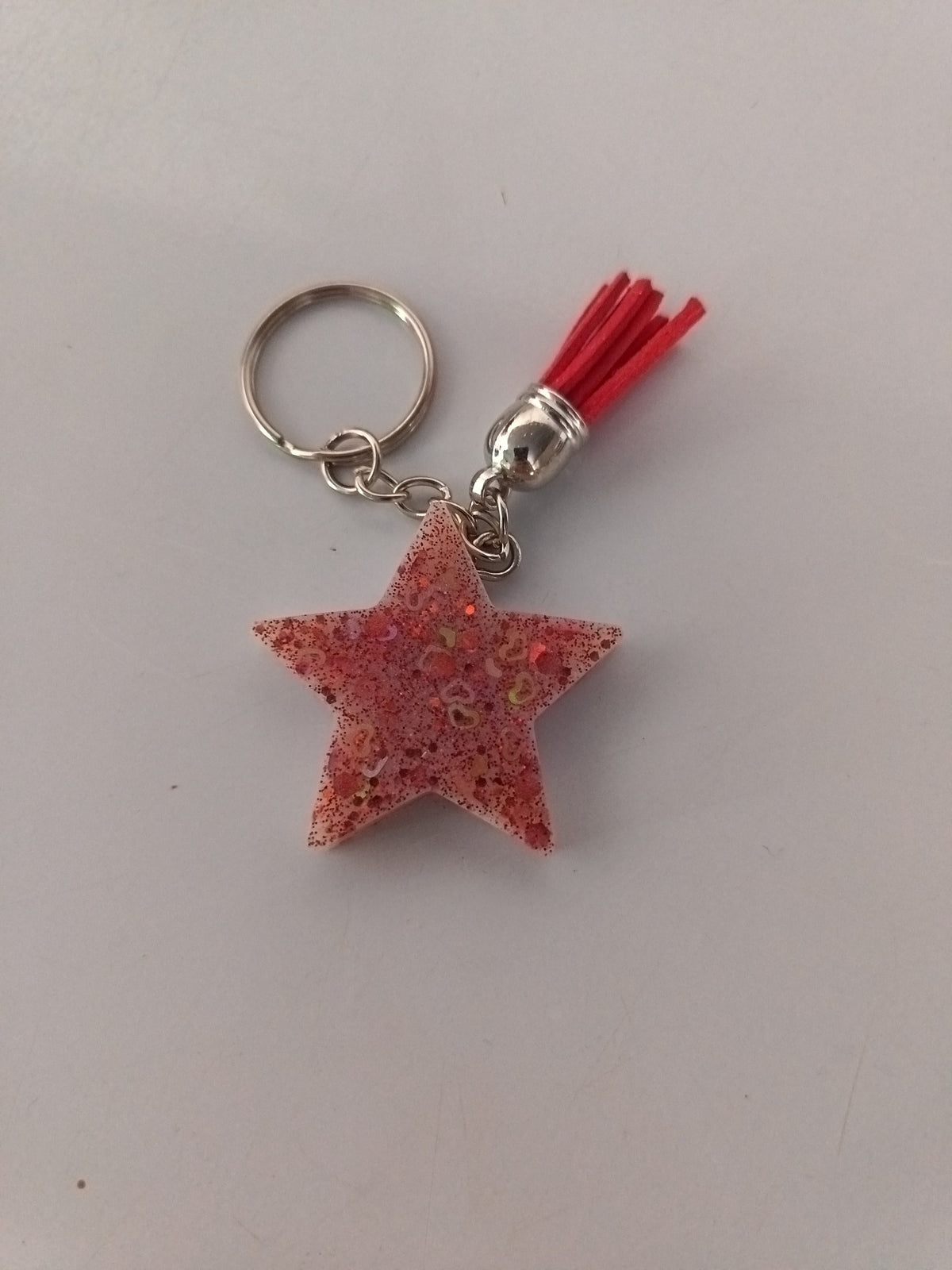 Porte-clé étoile en résine rose corail pailletée avec pompon suédine rouge