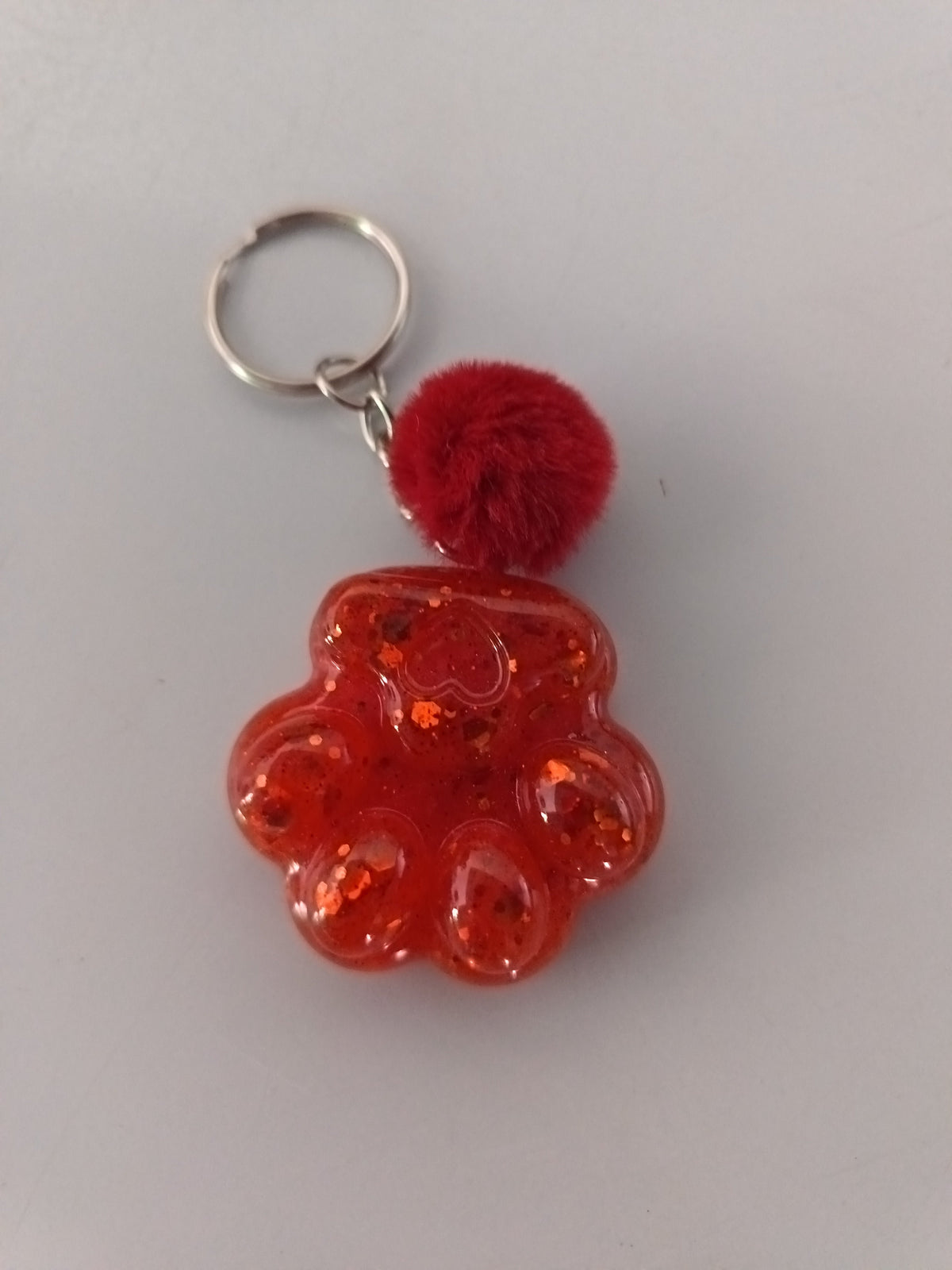 Porte-clé grosse patte de chien en résine rouge pailleté avec pompon boule de fourrure rouge