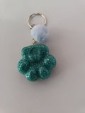 Porte-clé grosse patte de chien sculptée en résine vert émeraude pailleté avec pompon boule de fourrure bleu ciel