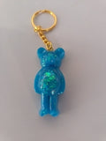 Porte-clé ourson sculpté en résine bleu turquoise pailleté avec chaînette et anneau dorés