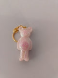 Porte-clé ourson sculpté en résine rose poudré nacré avec micro-paillettes roses et anneau doré