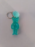 Porte-clé ourson sculpté en résine vert menthe translucide pailleté avec pompon boule de fourrure turquoise