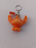 Porte-clé Stitch sculpté en résine orange vif translucide à grosses paillettes holographiques avec pompon suédine orange