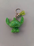 Porte-clé Stitch sculpté en résine vert fluo translucide à grosses paillettes holographiques avec pompon suédine jaune anis