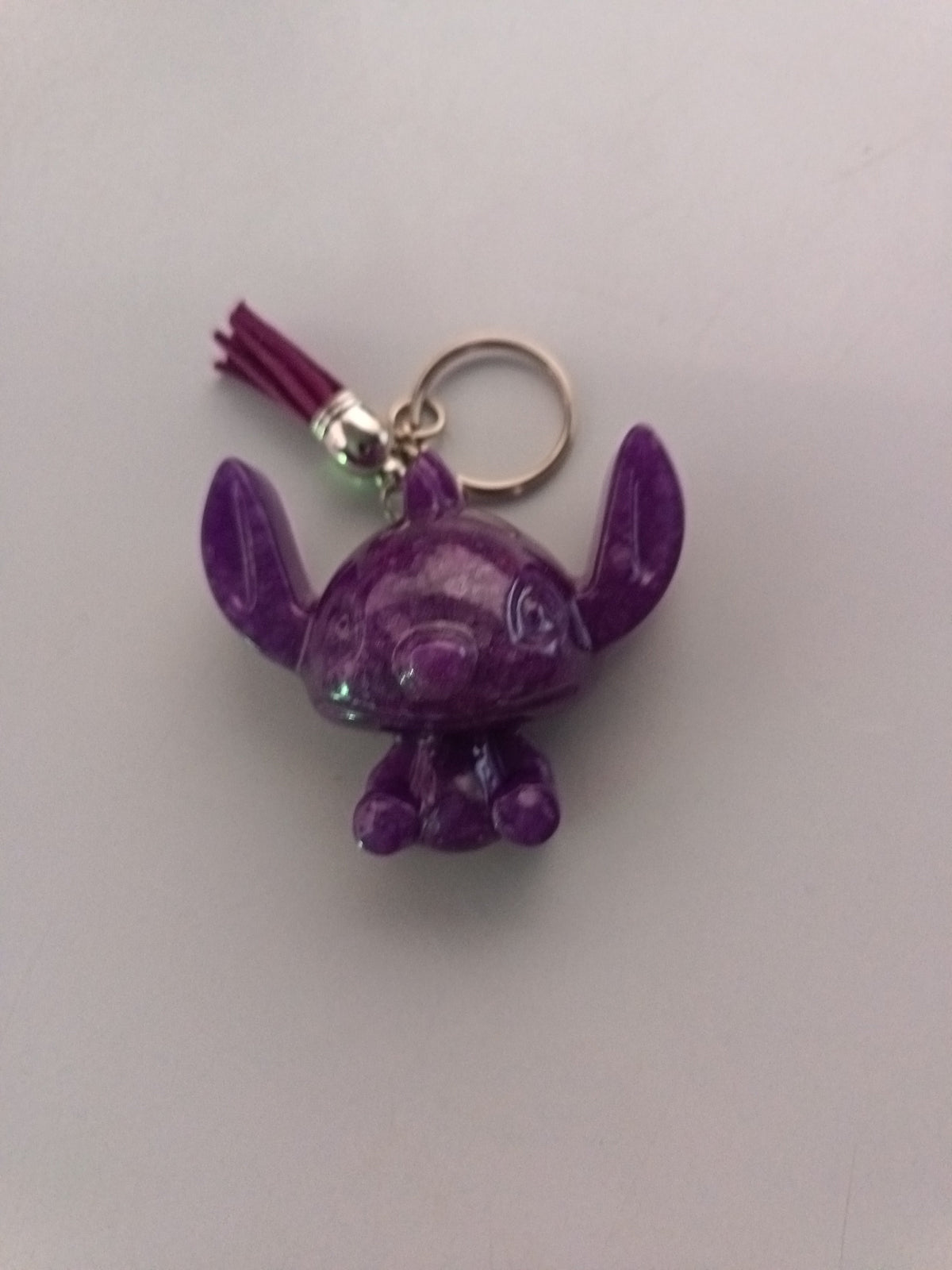Porte-clé Stitch sculpté en résine violet améthyste marbré avec pompon suédine bordeaux et anneau doré