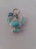 Porte-clé Stitch sculpté en résine blanc nacré translucide à grosses paillettes turquoise avec pompon suédine bleu ciel