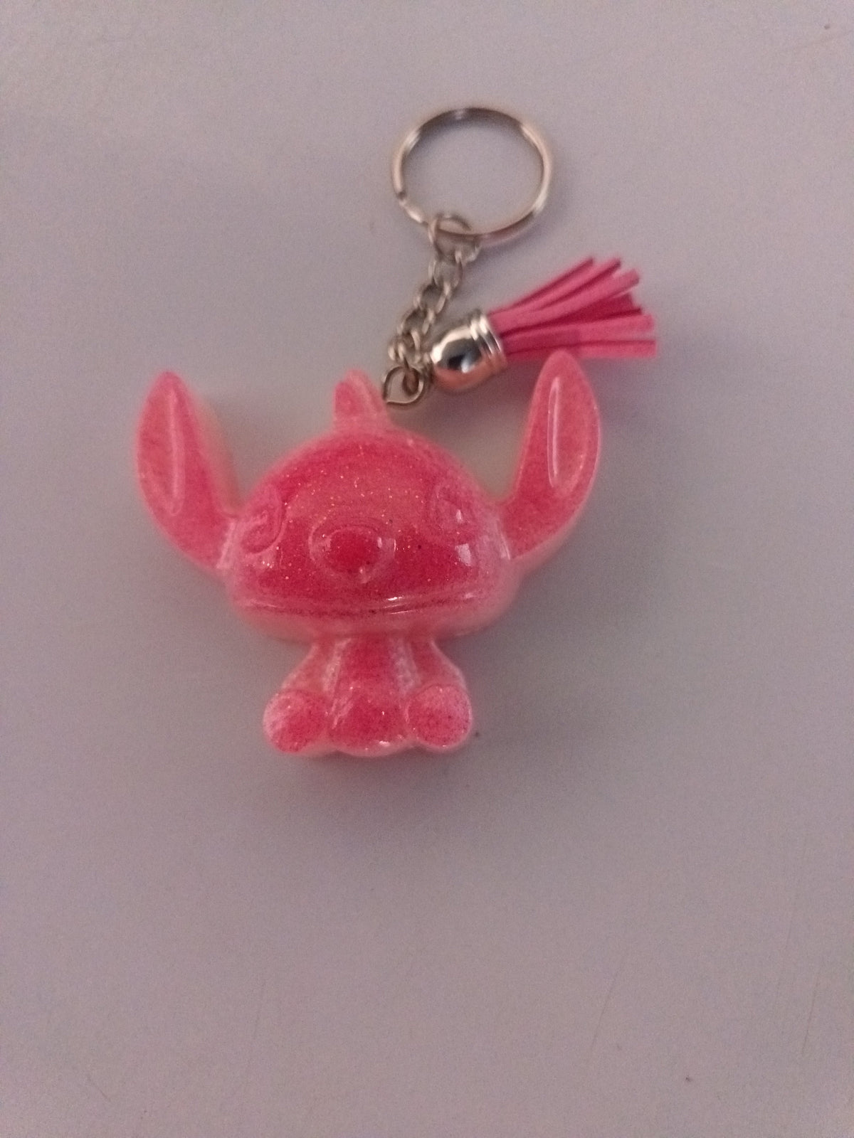 Porte-clé Stitch Angel sculpté en résine rose corail translucide pailleté avec pompon suédine fuchsia