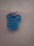 Porte-clé tête de Mickey sculptée en résine bleu turquoise translucide à grosses paillettes irisées avec pompon boule de fourrure blanche