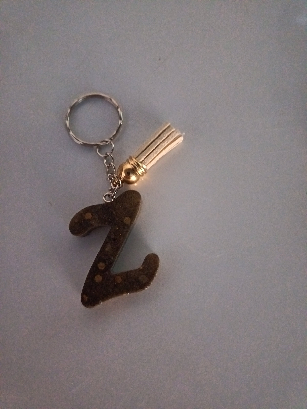 Porte-clé lettre Z sculptée en résine brun chocolat à paillettes dorées avec pompon suédine doré