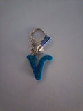 Porte-clé lettre V sculptée en résine bleu turquoise ultra-pailleté avec pompon suédine bleu lavande et chaînette argentée