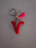 Porte-clé lettre V sculptée en résine rouge vif translucide avec pompon suédine rose fuchsia et chaînette argentée