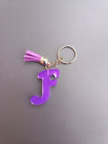Porte-clé lettre F sculptée en résine violet améthyste translucide à micro-paillettes avec pompon suédine violet fuchsia et chaînette dorée