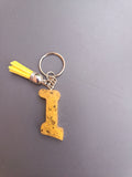 Porte-clé lettre I sculptée en résine jaune moutarde à éclats de feuilles d'or avec pompon suédine jaune fluo et chaînette argentée