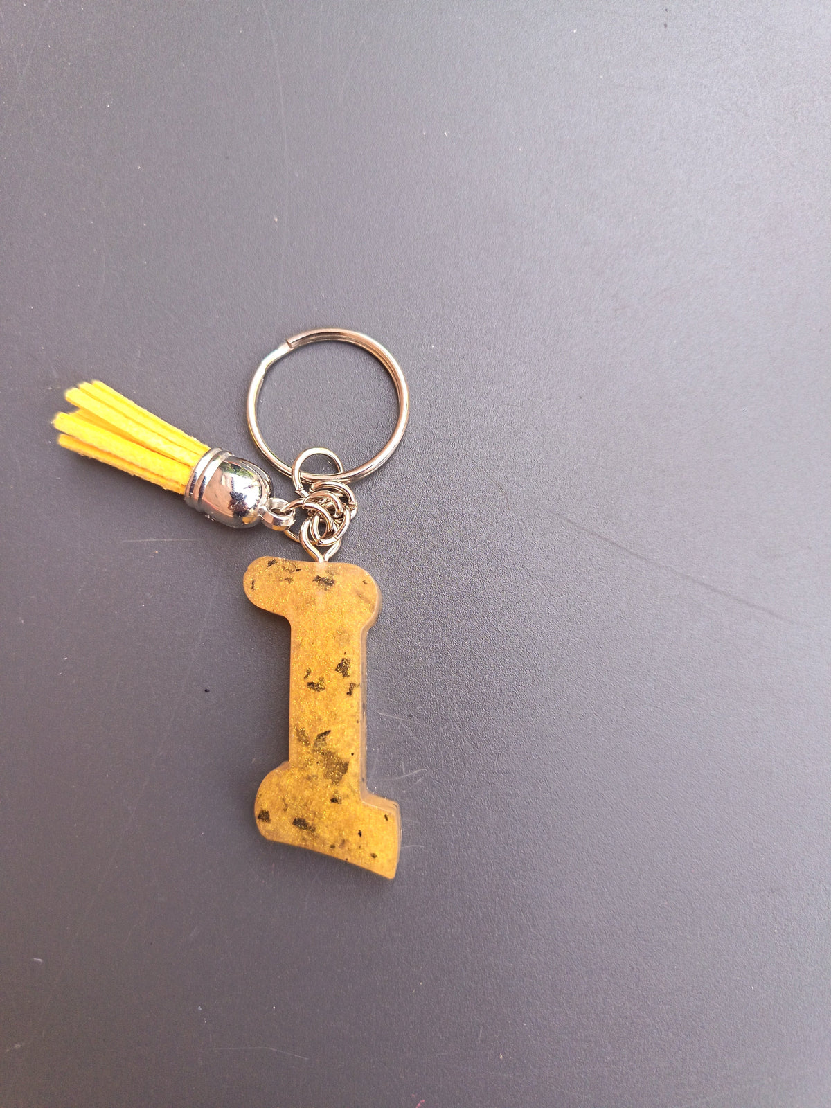 Porte-clé lettre I sculptée en résine jaune moutarde à éclats de feuilles d'or avec pompon suédine jaune fluo et chaînette argentée